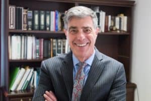 Lawyer posing in front of book case